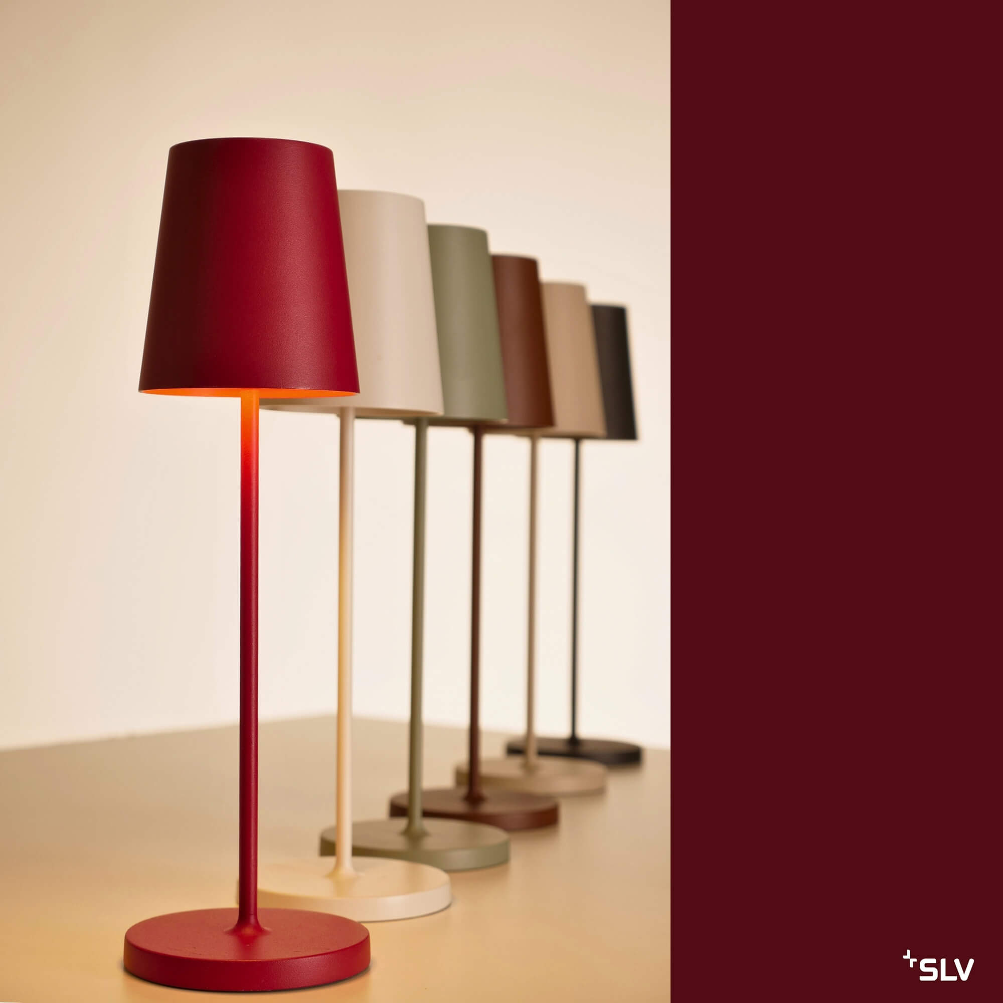 Outdoorlampe Vinolina Two mit roter Leuchte im Vordergrund und weiteren Farbvarianten im Hintergrund