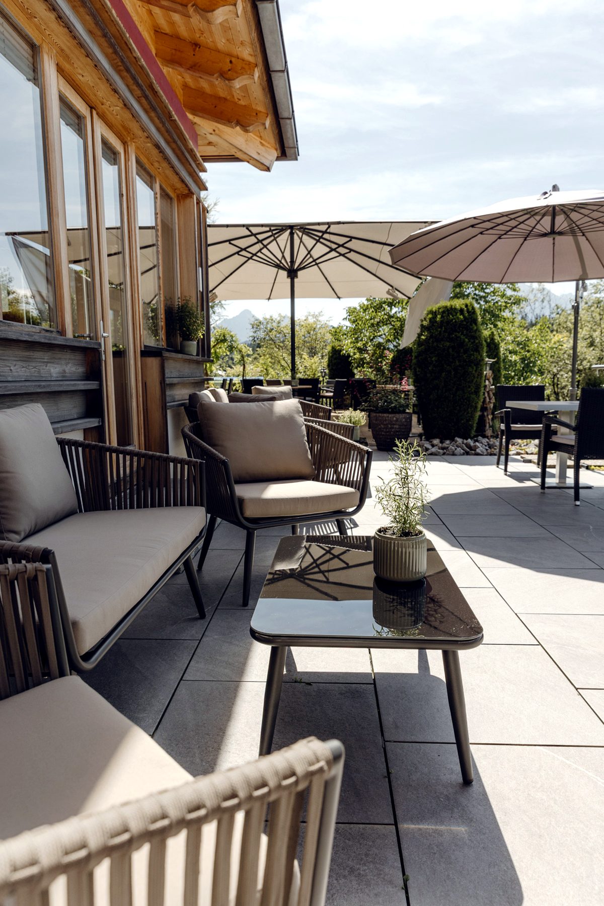 Hochformat der Sonnenterrasse im Landhotel zum Bad mit Loungeplätzen und Blick ins Grüne