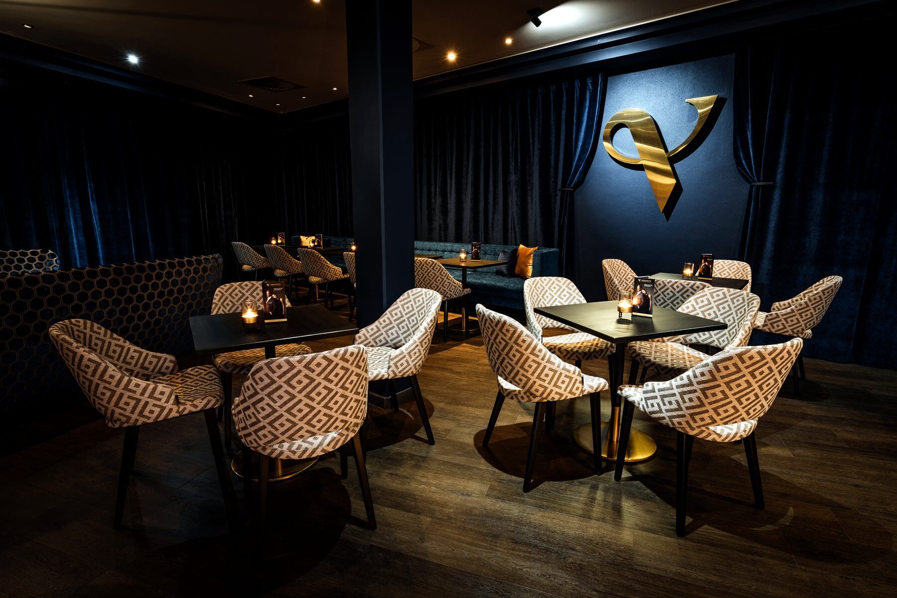 Tischgruppen in der Bar & Lounge des Zaubertheaters VERSCHMITTST mit Cizron-Stühlen und dunklem Boden