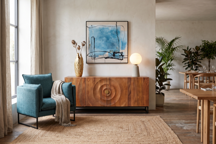 Wohnliche Dekoration mit Sessel und Holzkommode