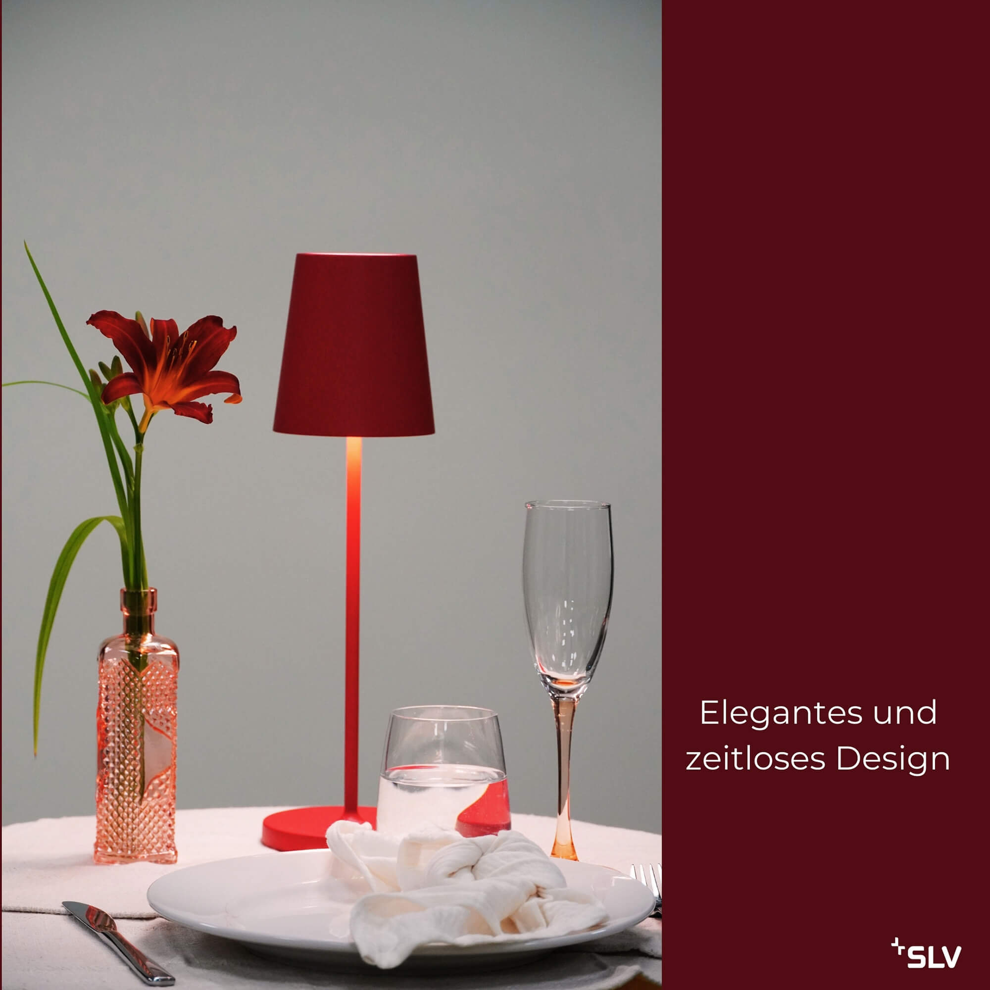 outdoorlampe Vinolina in Rot auf gedecktem Tisch mit Vase, Wasserglas und elegantem, zeitlosem Design