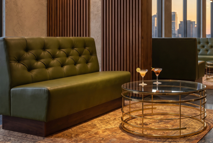 Grüne Lounge-Bank mit runden Couchtischen