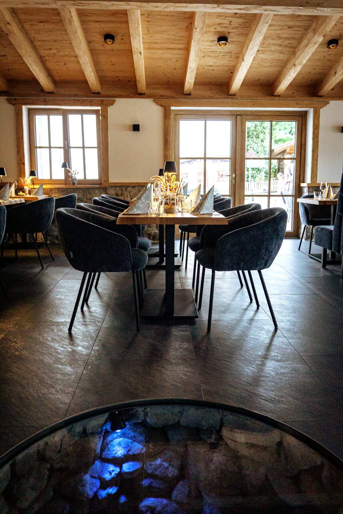 Hochformat des Gastraums im Restaurant Pfeiffer am Wörthsee mit Holzdecke, Tischen und Polsterstühlen