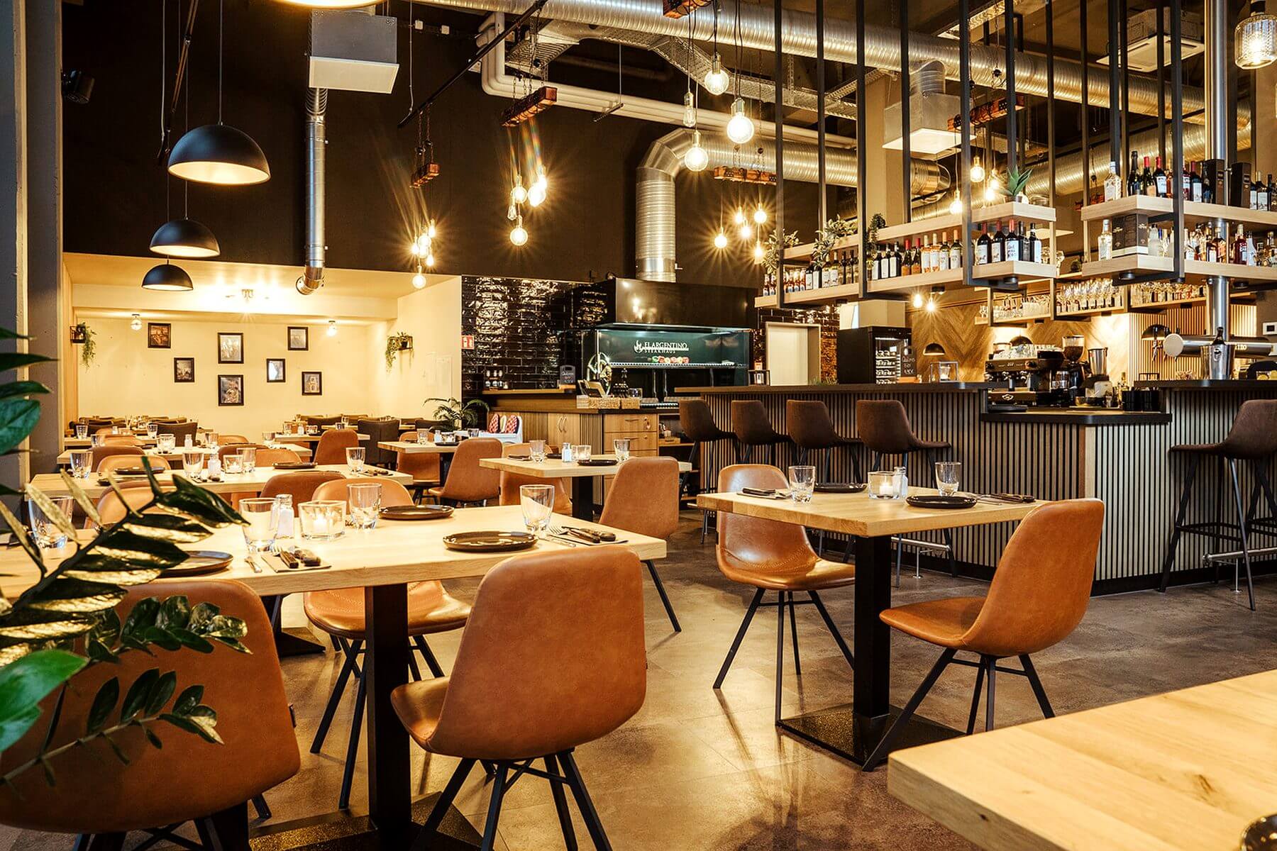 Innenbereich des El Argentino Steakhauses mit warmem Licht, Holzflächen und Restaurantbestuhlung