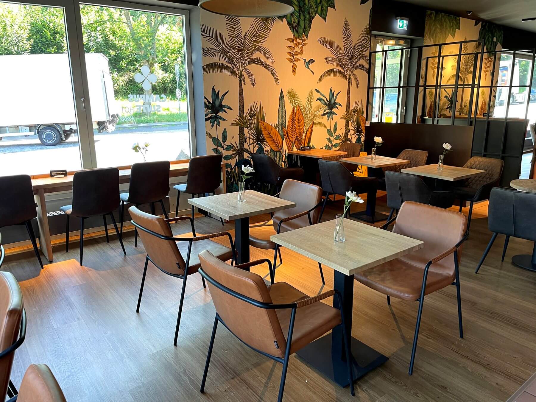 Gastraum bei Coffee Fellows Campus Suite im Westerwaldkreis mit Stühlen, Tischgruppen und warmer Wandgestaltung
