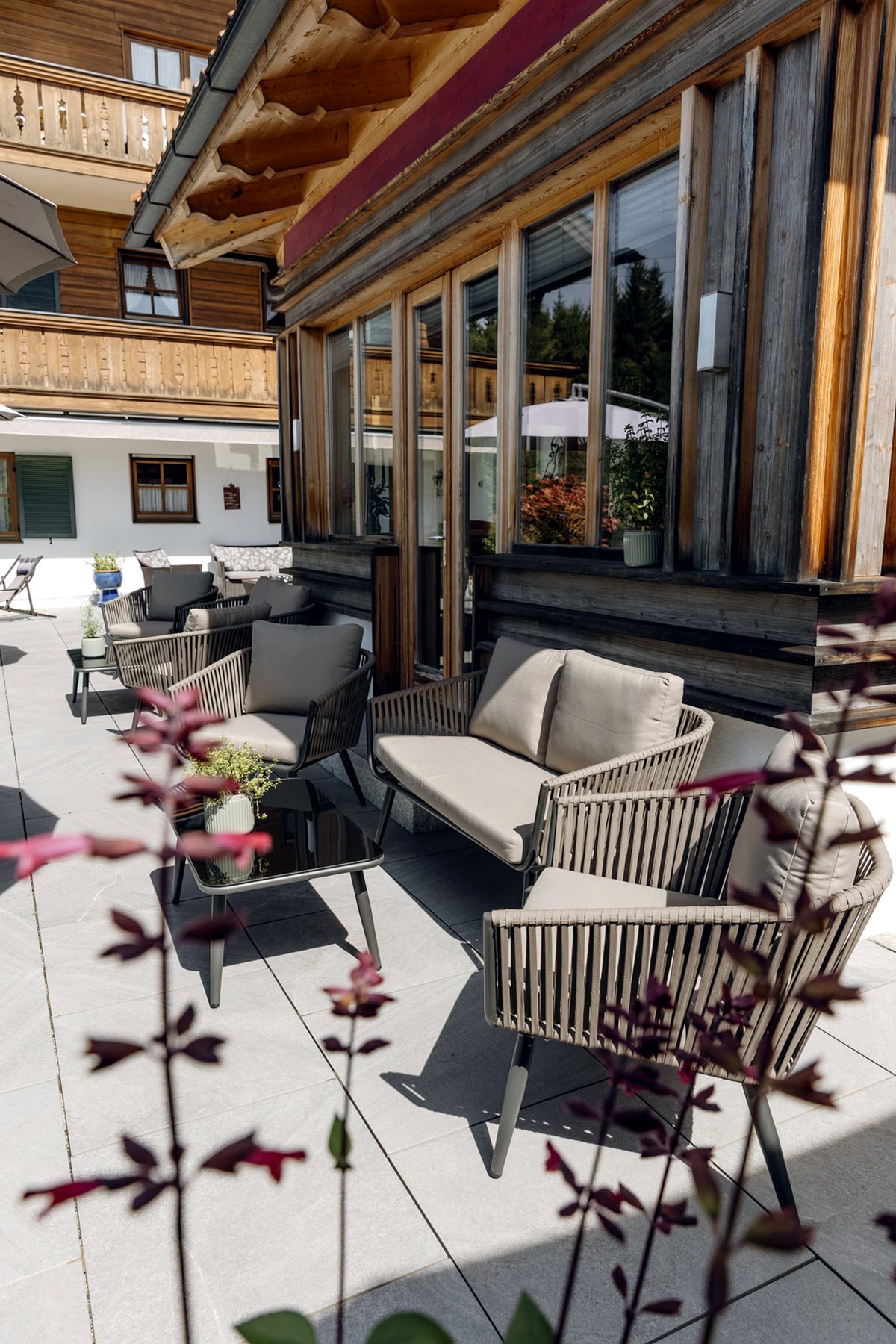 Hochformat einer Loungegruppe auf der Sonnenterrasse im Landhotel zum Bad in Krün