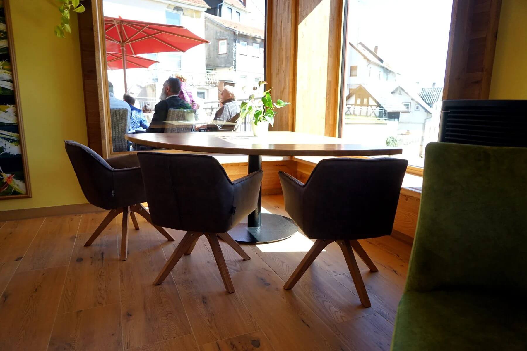 Fensterplatz im Dorfladen Café Marktgraitz mit Tischgestell Marino und gepolsterten Sitzmöbeln