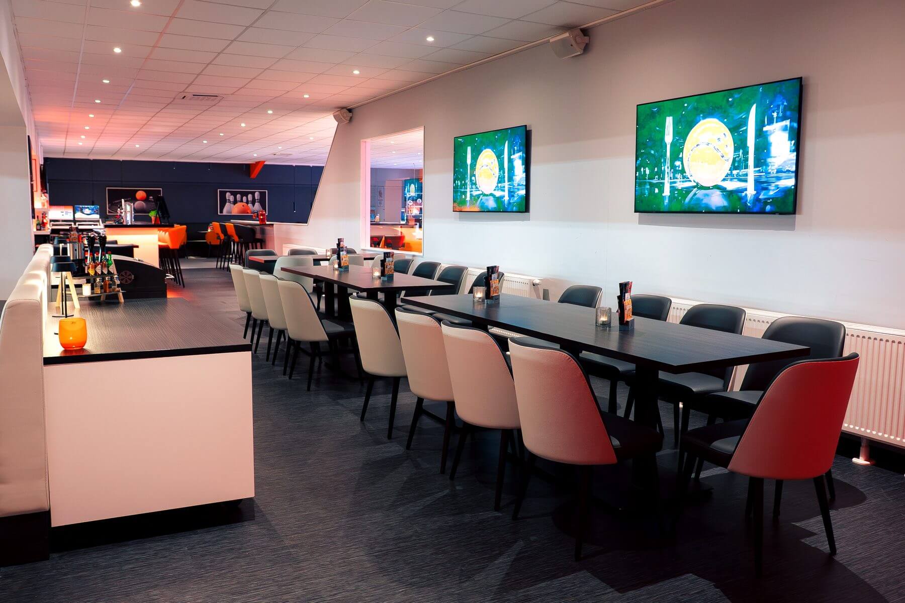 Tischreihe an der TV-Wand in der Players Lounge Finnentrop mit Sportsbar-Sitzplätzen