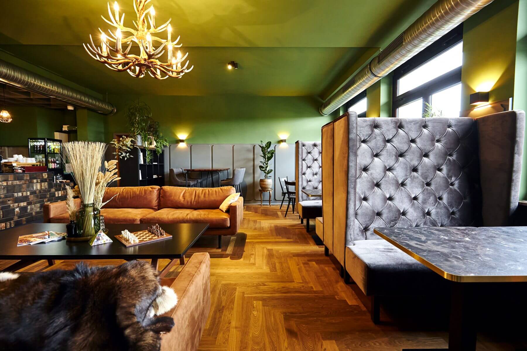 Gastraum und Lounge bei ERCK Bad Schönborn mit grüner Decke, Sofa und Banksystemen