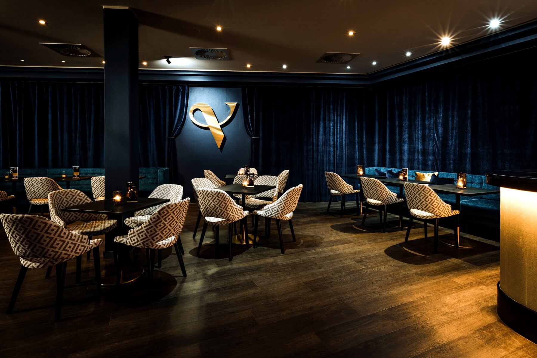 Übersicht der Bar & Lounge im Zaubertheater VERSCHMITTST mit Sitzgruppen, Theke und Logo an der Wand