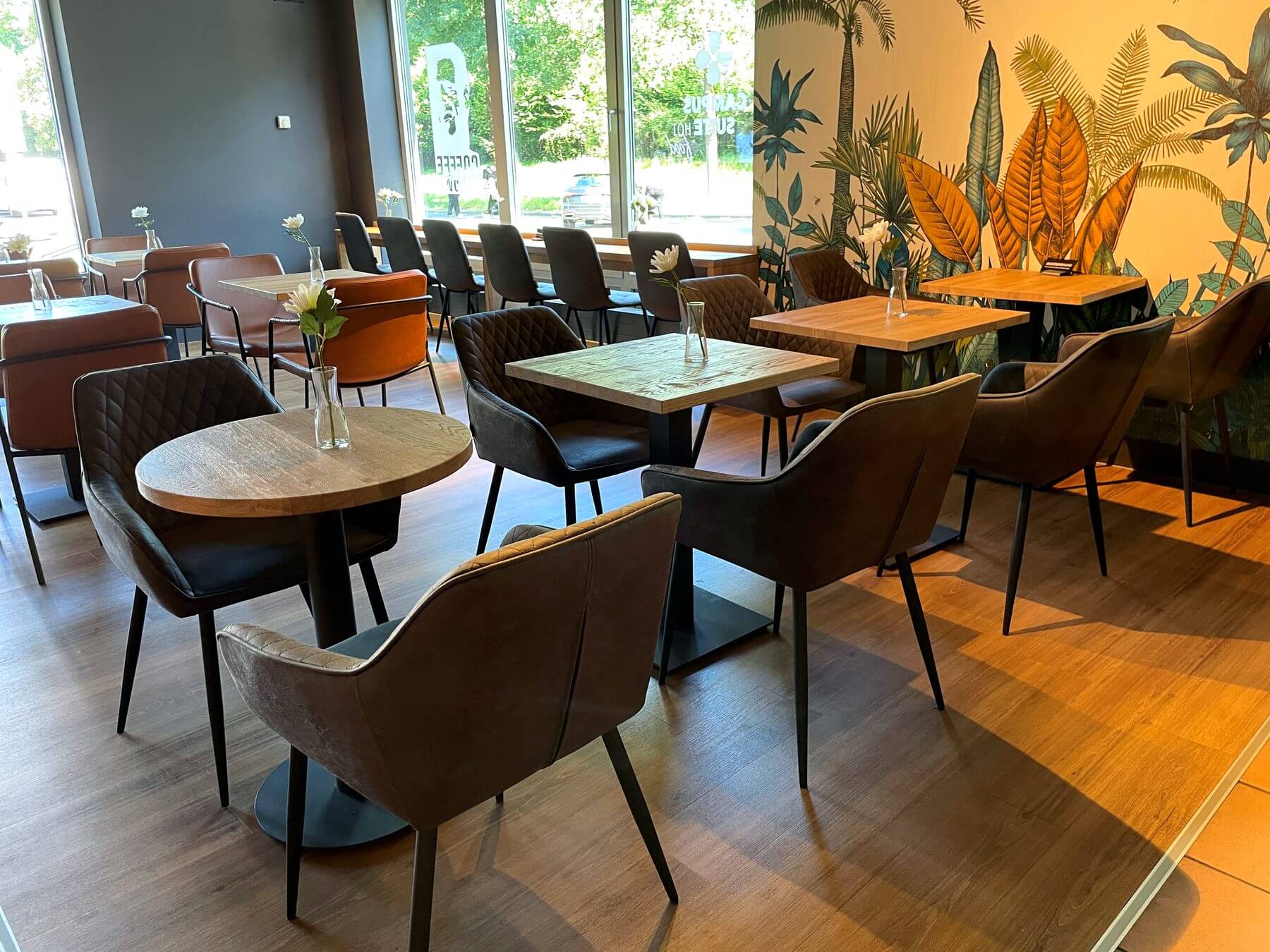 Gastraum bei Coffee Fellows Campus Suite mit Tischgruppen, Stühlen und markanter Coffee-Fellows-Wandgestaltung