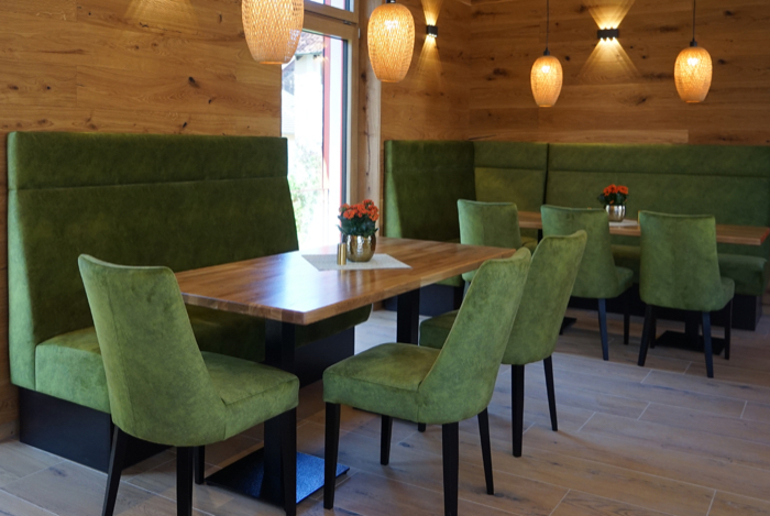 Grüne Sitzbank nach Maß an Restauranttischen