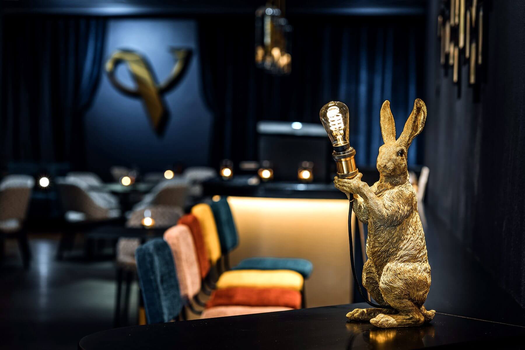 Dekoratives Detail in der Bar & Lounge von VERSCHMITTST mit Sitzmöbeln und Logo im Hintergrund